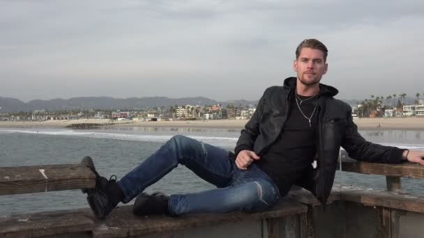 Yakışıklı Genç Adam Iskelede Ceketinin Kapüşonunu Çekiyor — Stok video