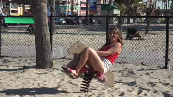Beztroska Młoda Kobieta Jeżdżąca Drewnianym Koniu Dla Dzieci Placu Zabaw — Wideo stockowe