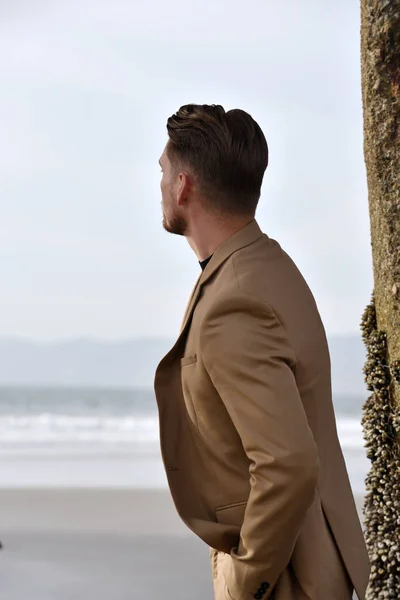 Handsome young man looking out to sea — Stock Photo, Image