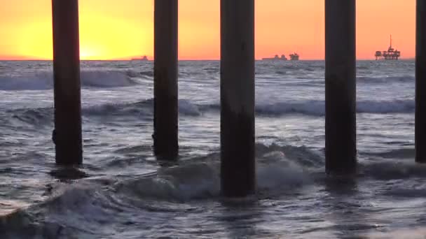 从码头下看到的落日 有海上石油钻井平台 — 图库视频影像