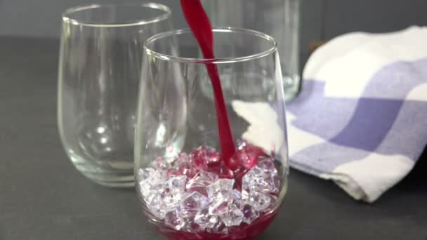 クランベリージュースを氷のガラスに入れる — ストック動画