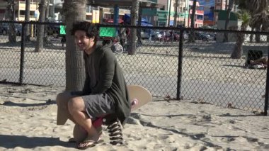 Çocuk parkında oyuncak ata binen genç adam.