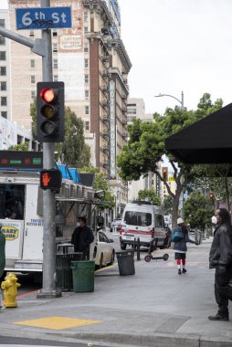 Los Angeles, CA / USA - 9 Nisan 2020: Yüzü maskeli bir adam Los Angeles şehir merkezinde bir yemek kamyonunda yemek bekliyor