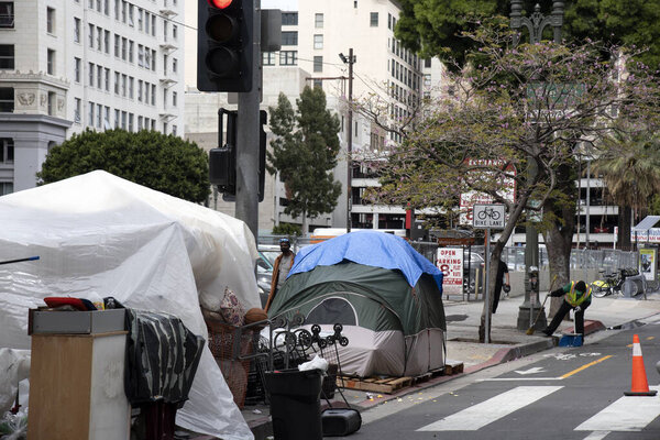 Los Angeles, CA/USA - April 9, 2020: City sanitation workers attempt to clean the streets around the tents of the homeless during COVID-19 outbreak