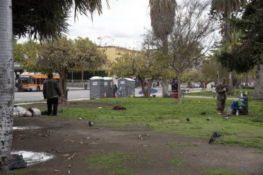 Los Angeles, CA / USA - 9 Nisan 2020: COVID-19 karantinası sırasında büyüyen evsiz nüfus için MacArthur Park 'taki taşınabilir tuvaletler ve el yıkama istasyonları