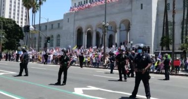 Los Angeles, CA / USA - 1 Mayıs 2020: Polis hatları COVID-19 karantinasına karşı düzenlenen belediye mitinginde protestocuları kontrol ediyor