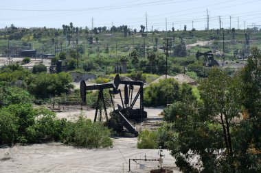 Depolama tanklarıyla petrol sahasında çalışan pompalar