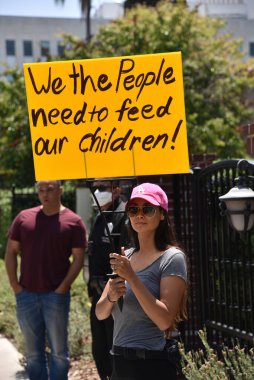 Los Angeles, CA / USA - 8 Mayıs 2020: Covid-19 karşıtı protestocu çocuğunu beslemesi gerektiğini belirten bir tabela tutuyor