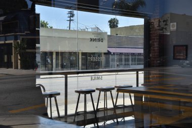 Los Angeles, CA / USA - 9 Mayıs 2020: Terkedilmiş cadde ve kapalı bir restoranın penceresinden Coronavirus Quantin sırasında görülen dükkanlar