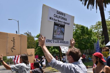 Los Angeles, CA / USA - 8 Mayıs 2020: Anti-Covid-19 karantina protestocusu sokaklardaki evsizlerin görmezden gelinen sağlık sorununa işaret ediyor