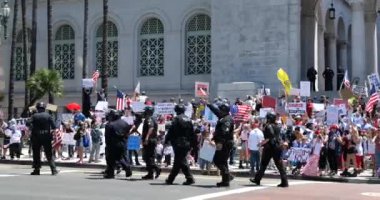 Los Angeles, CA / USA - 1 Mayıs 2020: COVID-19 karantinasına karşı belediye mitinginde protestocuları kontrol eden bisiklet polisi