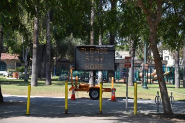 Lütfen Coronavirus karantinası sırasında Batı Hollywood 'daki Plummer Park' ta ev tabelasını imzalayın.