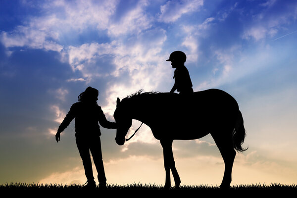 child on horseback at sunset