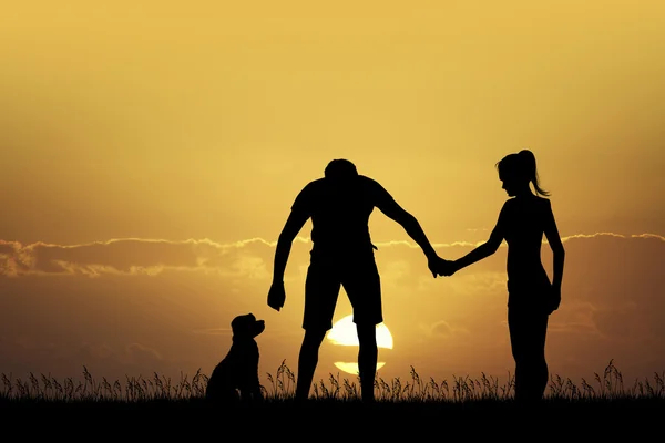 Couple avec chien au coucher du soleil — Photo