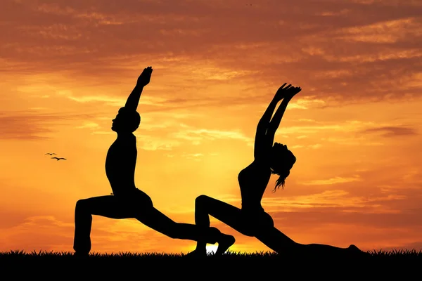Gün batımında yoga yaparken çift — Stok fotoğraf