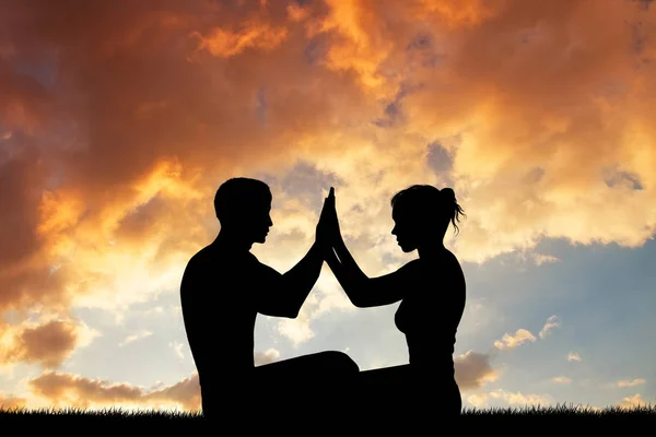 Couple doing yoga at sunset — Stock Photo, Image