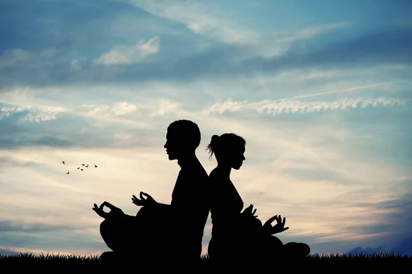 Couple doing yoga at sunset — Stock Photo, Image