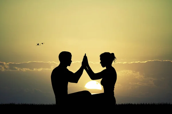 Par gör yoga vid solnedgången — Stockfoto