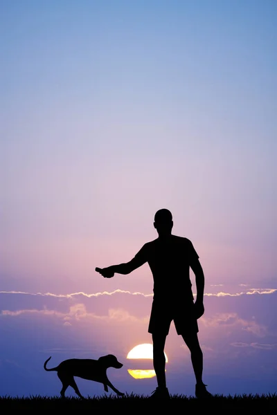 Homem joga com o seu cão ao pôr do sol — Fotografia de Stock