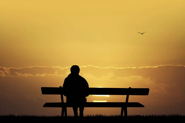 Muž na lavičce při pohledu na západ slunce — Stock fotografie