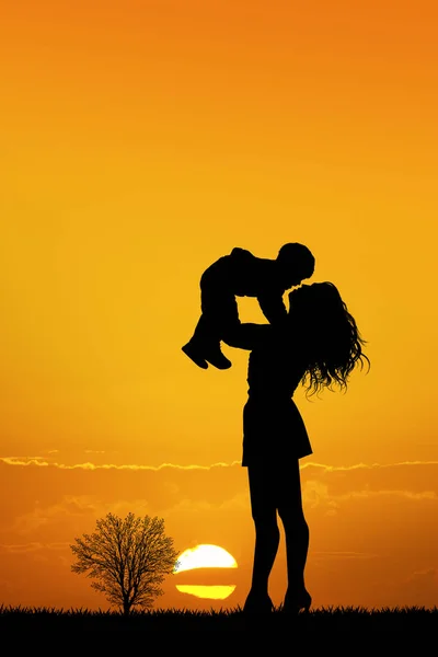 Mulher feliz com filho ao pôr do sol — Fotografia de Stock