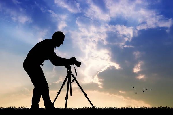 Mann mit Kamera auf Stativ bei Sonnenuntergang — Stockfoto