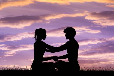 erkek ve kadın gün batımında yoga yaparken gösteren resim