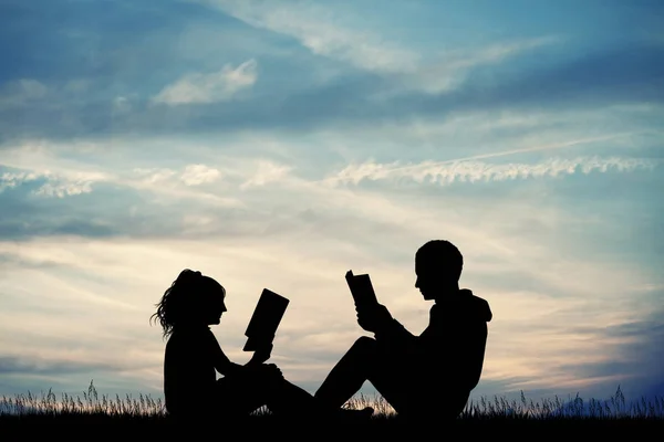 illustration of man and woman reading a book at sunset