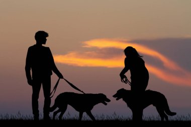 köpeklerle günbatımında Çift