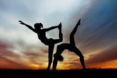 iki kız şafakta yoga yapmak