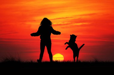 Gün batımında köpekli kız