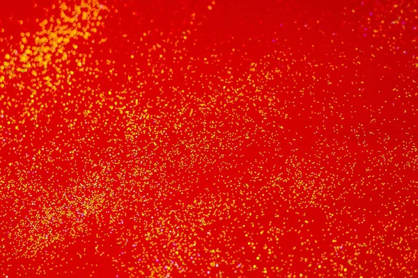 Goldene Funkeln auf rotem Hintergrund. — Stockfoto