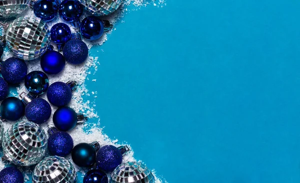 Fronteira de Natal. Bolas de Natal e neve branca no fundo azul. Espaço de cópia, vista superior . Imagens De Bancos De Imagens Sem Royalties