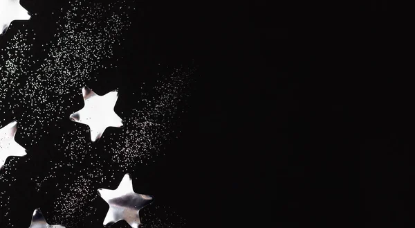 Estrelas de prata e brilhos sobre fundo preto. Flat lay, espaço de cópia . Fotos De Bancos De Imagens
