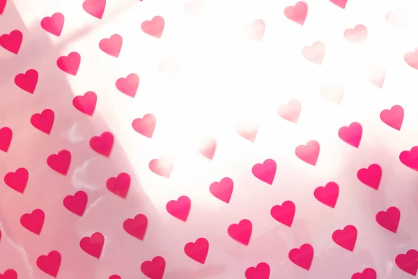 Pattern made of hearts on pink background with sun glare. Abstract love, St. Valentine's day backdrop. Top view, soft focus. — 스톡 사진