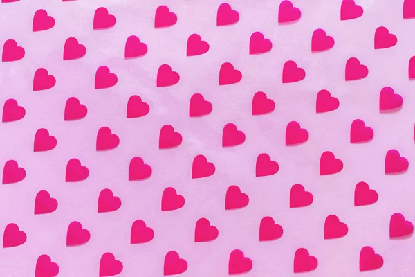 Muster aus Herzen auf rosa Hintergrund. abstrakte Liebe, Hintergrund des Valentinstages. Draufsicht, weicher Fokus. — Stockfoto