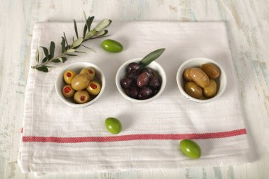 Üç tür bir bez peçete üzerinde zeytin ve genç zeytin dalı