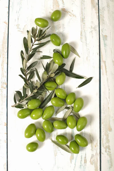 Skördade färska Oliver med unga oliv kvistar på trä backgrou — Stockfoto