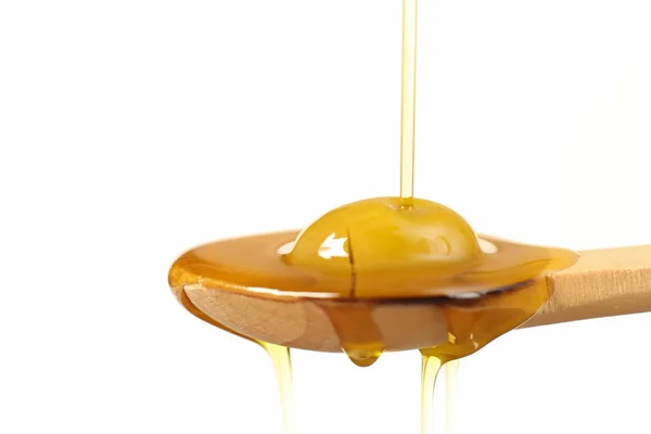 Vista ravvicinata dell'olio vergine di oliva versato sul cucchiaio di legno — Foto Stock