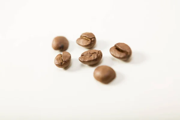 Macro bild av mörka aromatiska kaffebönor på vit bakgrund — Stockfoto