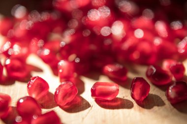 Açık kırık bir nar meyve. Tohum ahşap üzerine dökülüp