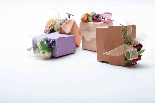 Gift boxes with ribbon and artificial flowers on white backgroun — Stock Photo, Image