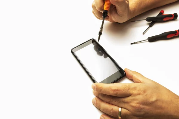 Hombre usando destornilladores de precisión en su Smartphon —  Fotos de Stock