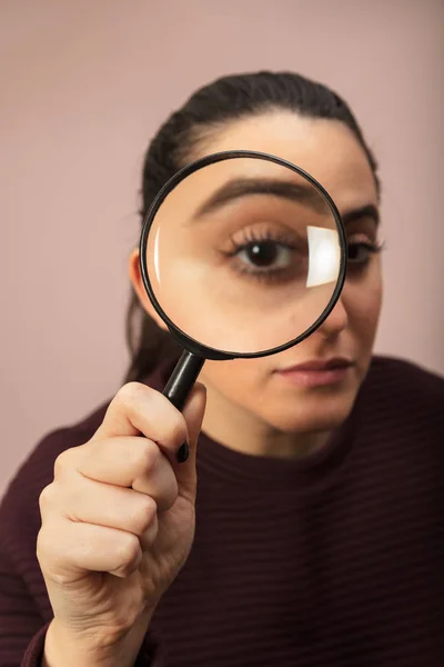 Woman looking through magnifying glass — Stock Photo, Image