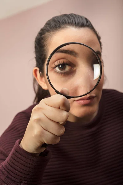 Woman looking through magnifying glass