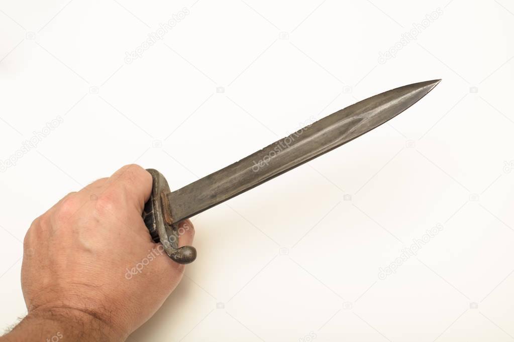 Hand holding old bayonet in close up view