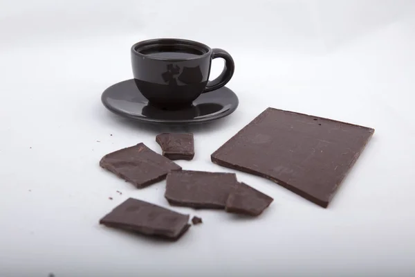 Black cup of coffee with chocolate  on gray surface — Stock Photo, Image