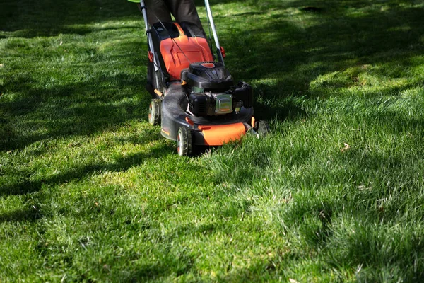 Cortacésped cortando hierba verde. Trabajo en el jardín — Foto de Stock