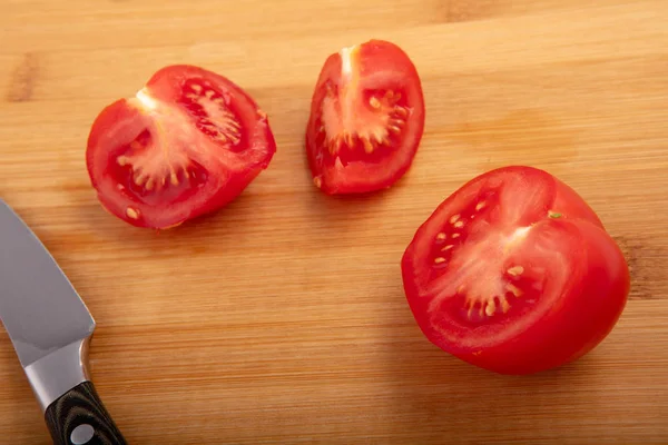 Ripe tomato slices on wooden surface