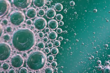 Sıvının içinde oksijen veya hava kabarcıkları. Makro. Sudaki oksijen kabarcıkları, turkuaz arka plan, ekoloji, saflık ve sıvı veya suyla ilgili diğer kavramlar.